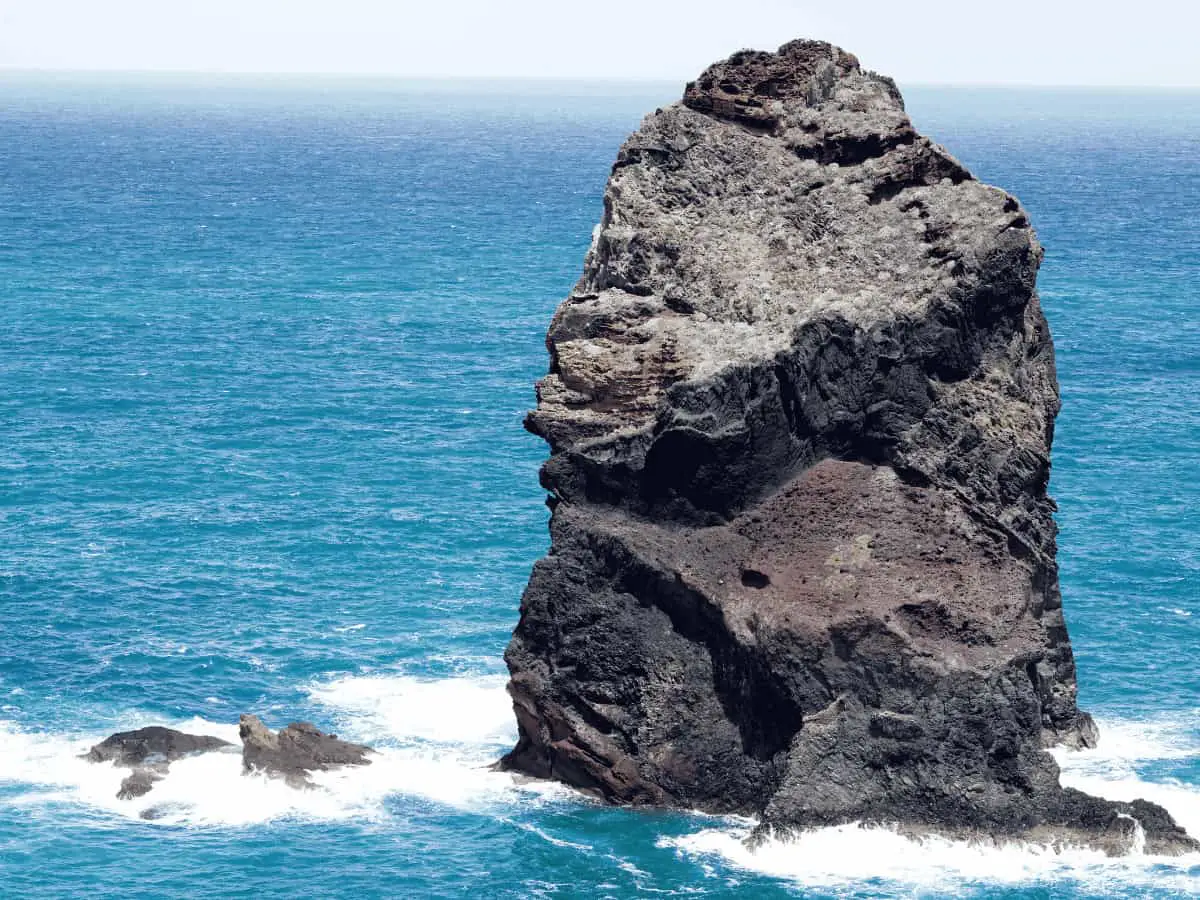 Ein einzelner Felsen ragt aus stürmischer See – Symbol für Standfestigkeit, innere Haltung und Integrität in bewegten Zeiten.